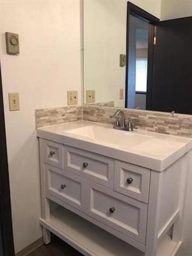 bathroom featuring vanity and backsplash