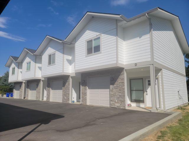 1814 E Carol St, Deer Park, WA 99006 - townhome / multi-family property featuring an attached garage, driveway, and stone siding