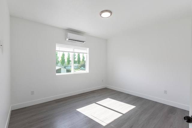 unfurnished room with dark hardwood / wood-style floors and a wall unit AC