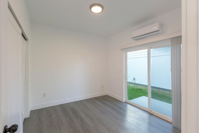 1814 E Carol St, Deer Park, WA 99006 - unfurnished bedroom featuring a wall unit AC, wood finished floors, access to outside, baseboards, and a closet