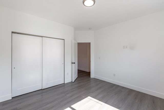 unfurnished bedroom with a closet and hardwood / wood-style floors