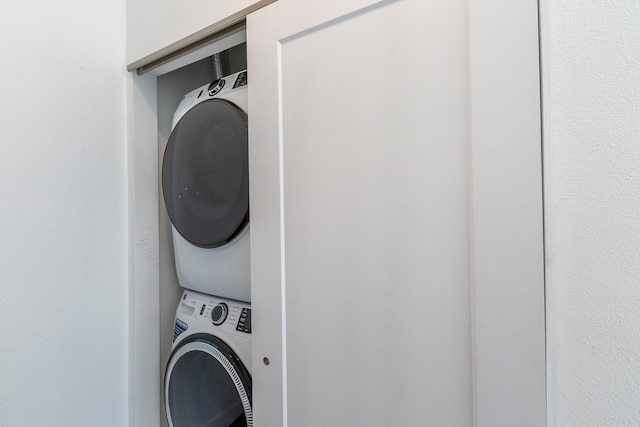 washroom featuring stacked washing maching and dryer