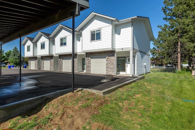 1814 E Carol St, Deer Park, WA 99006 - view of front of house with an attached garage, stone siding, a front yard, and driveway