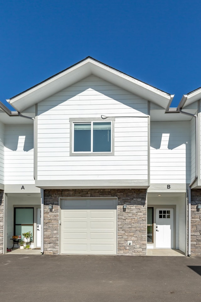 1814 E Carol St, Deer Park, WA 99006 - townhome / multi-family property featuring stone siding, an attached garage, and driveway