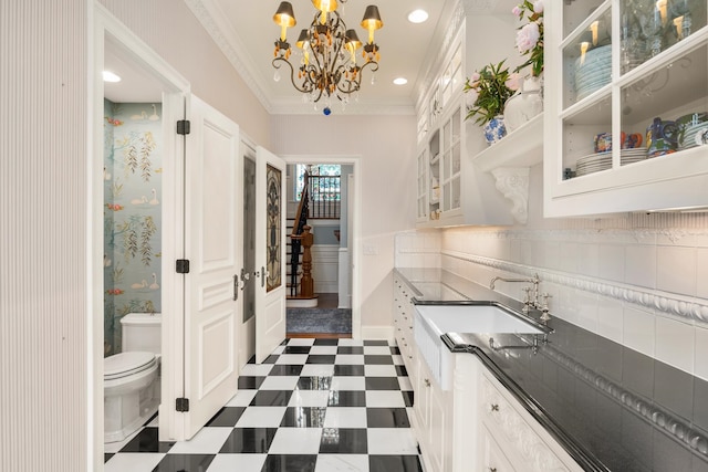 kitchen featuring pendant lighting, white cabinetry, dark tile patterned floors, and decorative backsplash