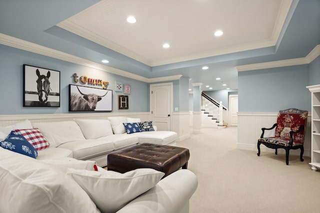 carpeted living room with ornamental molding and a tray ceiling