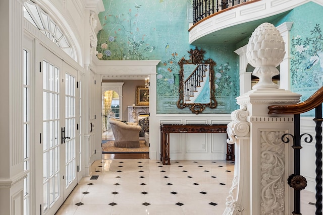 tiled entryway featuring french doors and a towering ceiling