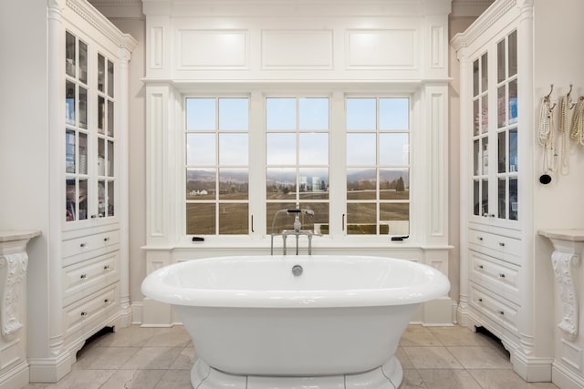 bathroom featuring tile patterned flooring, a washtub, and a healthy amount of sunlight