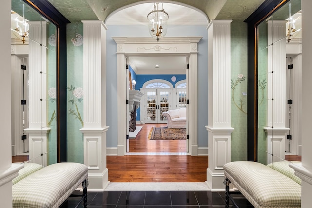 corridor with decorative columns, crown molding, french doors, and hardwood / wood-style flooring