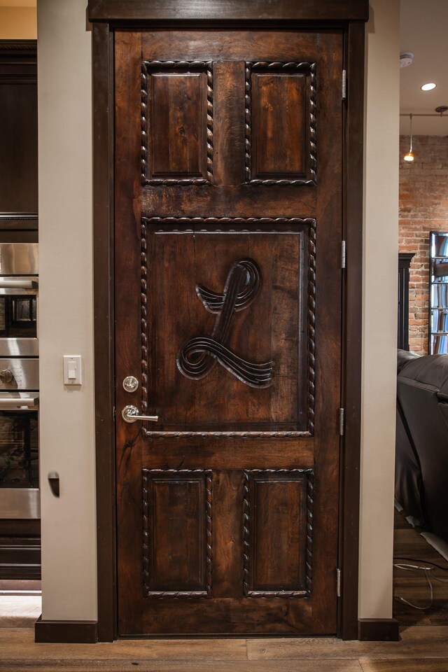 details featuring stainless steel double oven and hardwood / wood-style floors