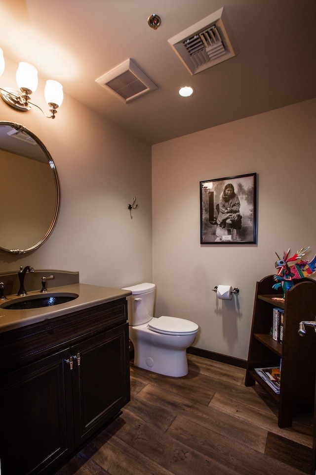 bathroom with vanity, toilet, and hardwood / wood-style flooring