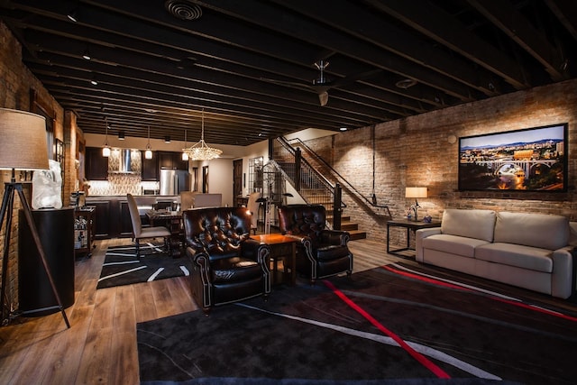 interior space featuring stainless steel fridge, wood-type flooring, and brick wall