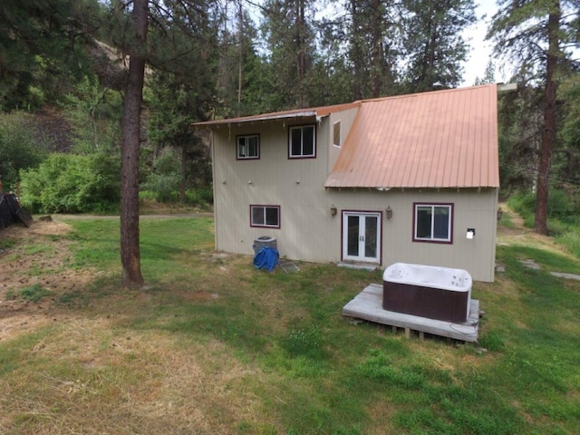 back of house featuring a yard and french doors