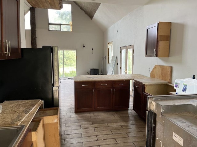 kitchen featuring high vaulted ceiling and light wood-type flooring