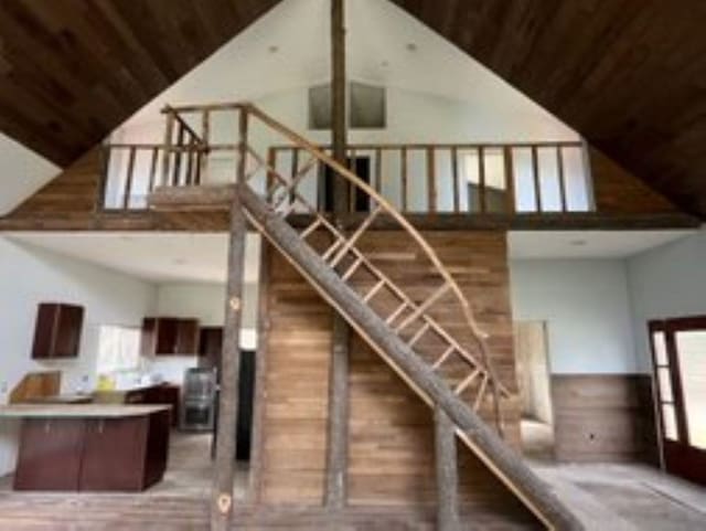 stairway with hardwood / wood-style flooring, high vaulted ceiling, and wooden ceiling