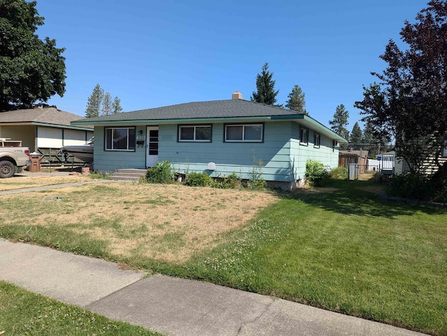 single story home featuring a chimney, fence, and a front lawn