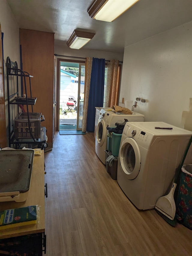 laundry area featuring laundry area, washing machine and clothes dryer, and wood finished floors