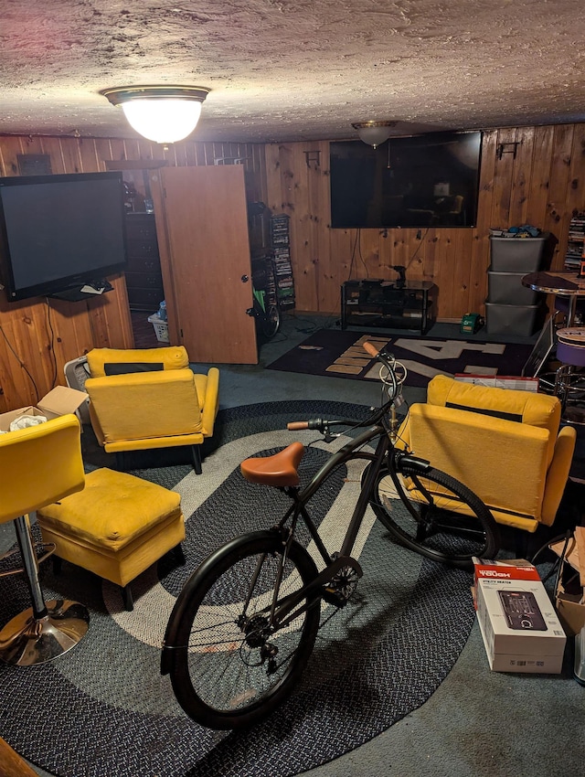 interior space with carpet floors, wood walls, and a textured ceiling