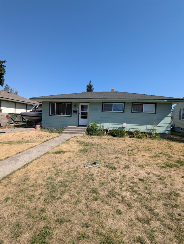 ranch-style home featuring entry steps and a front lawn