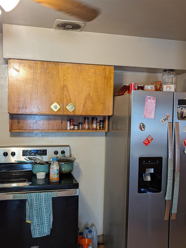 kitchen featuring visible vents, electric range, and stainless steel fridge with ice dispenser