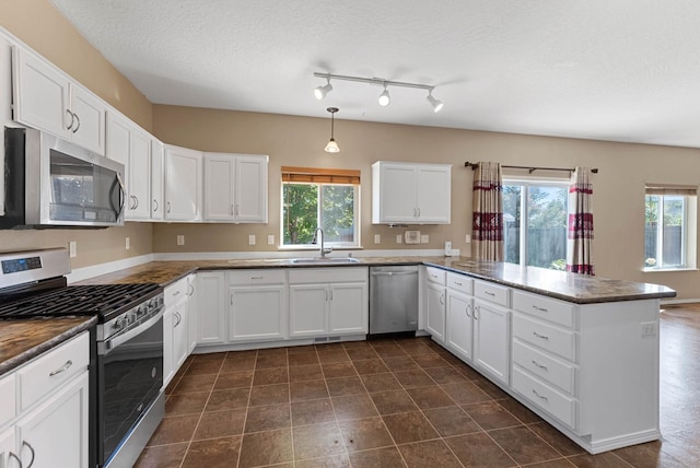 kitchen with white cabinetry, sink, kitchen peninsula, and appliances with stainless steel finishes