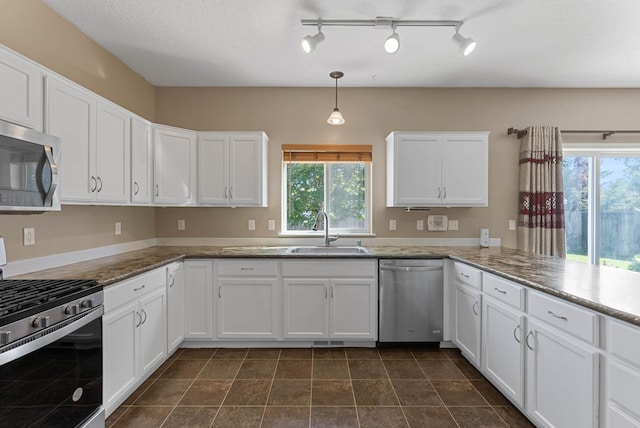 kitchen featuring sink, hanging light fixtures, kitchen peninsula, stainless steel appliances, and white cabinets