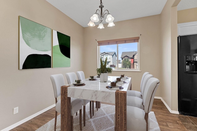 dining space featuring dark hardwood / wood-style floors and a chandelier