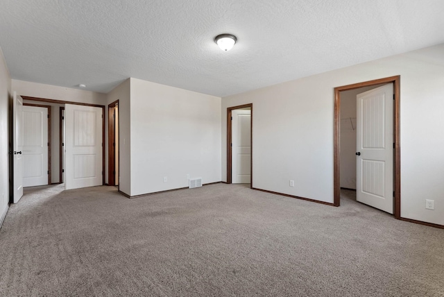 unfurnished bedroom with light carpet and a textured ceiling