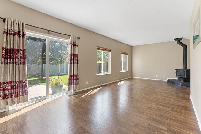 unfurnished living room featuring a wood stove and dark hardwood / wood-style floors