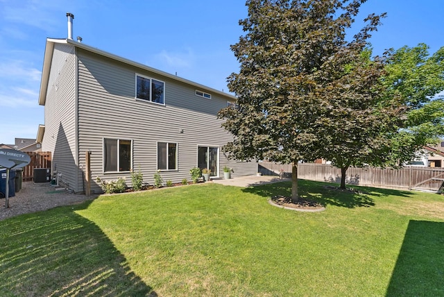 back of house featuring cooling unit and a yard