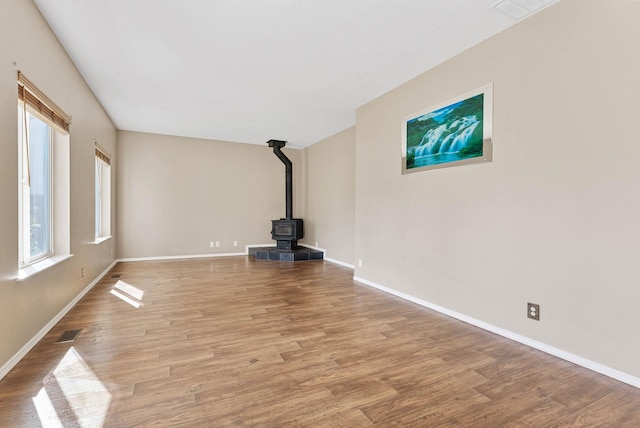 unfurnished living room featuring light hardwood / wood-style flooring and a wood stove