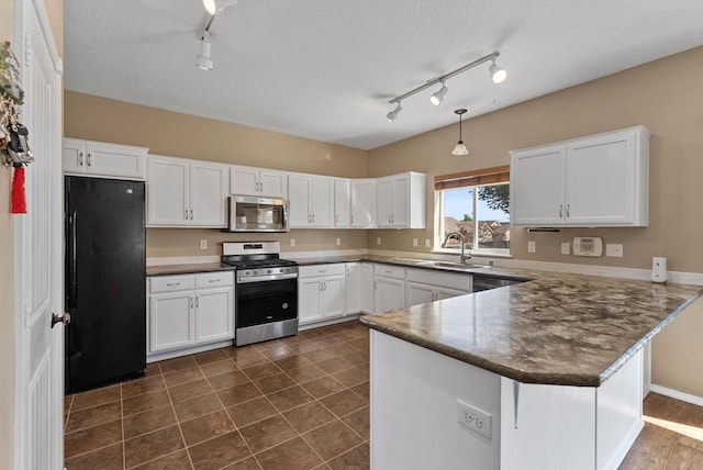 kitchen with sink, decorative light fixtures, appliances with stainless steel finishes, kitchen peninsula, and white cabinets