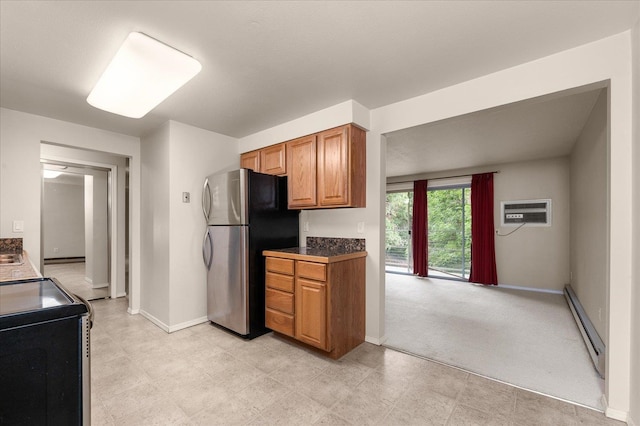 kitchen featuring range with electric stovetop, a wall mounted air conditioner, stainless steel refrigerator, baseboard heating, and light carpet