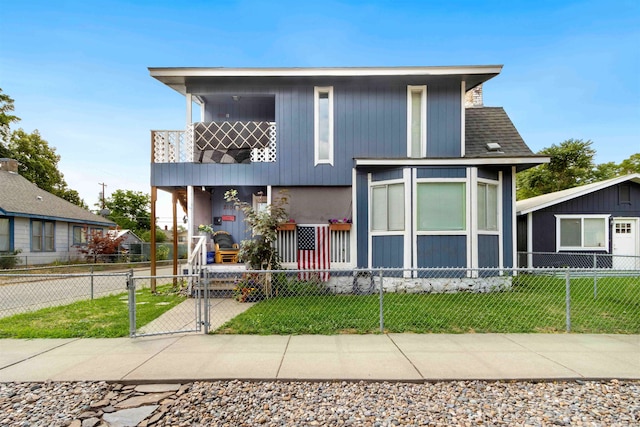 view of front of property featuring a balcony and a front yard