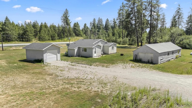 view of front of house featuring a garage, an outbuilding, and a front yard