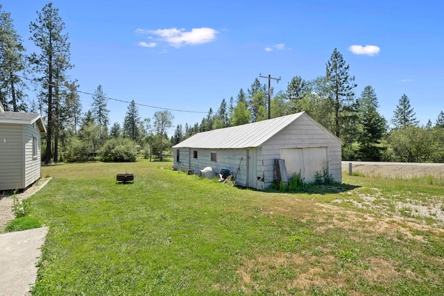 view of yard featuring a storage unit and an outdoor fire pit