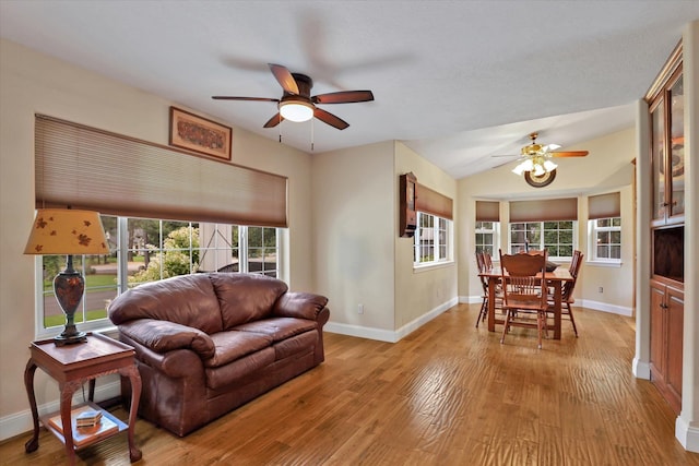 living room with plenty of natural light, ceiling fan, and light hardwood / wood-style floors