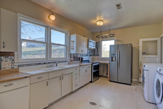 kitchen featuring stainless steel appliances, light countertops, visible vents, white cabinets, and a sink