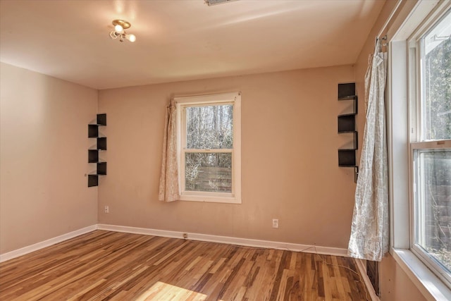 spare room featuring light wood-type flooring and baseboards