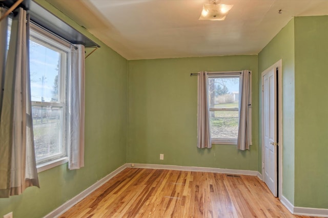 unfurnished room with light wood-type flooring and baseboards