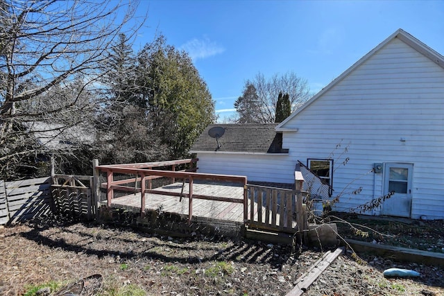 rear view of property featuring roof with shingles and a wooden deck