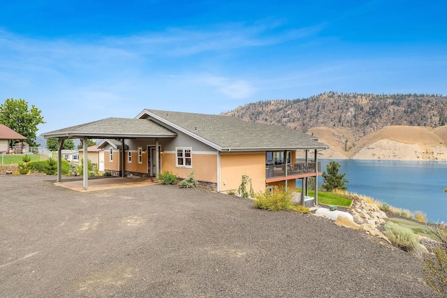 view of front of home featuring a balcony and a water and mountain view