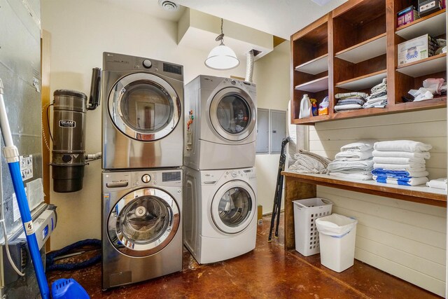 clothes washing area featuring electric panel and stacked washer / drying machine