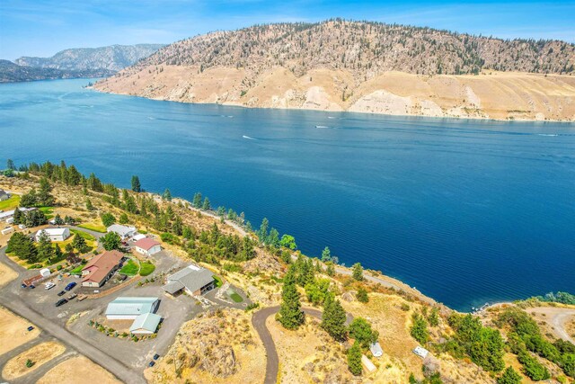 birds eye view of property with a water and mountain view