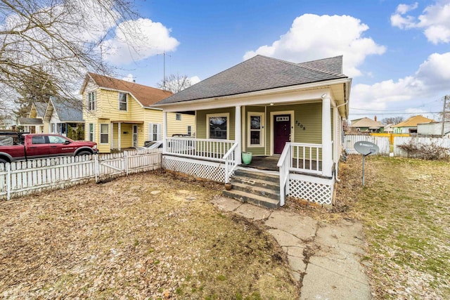 view of front of house featuring roof with shingles, a porch, and fence