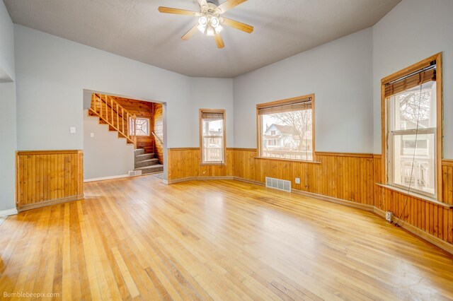 unfurnished room featuring ceiling fan, wood-type flooring, and plenty of natural light