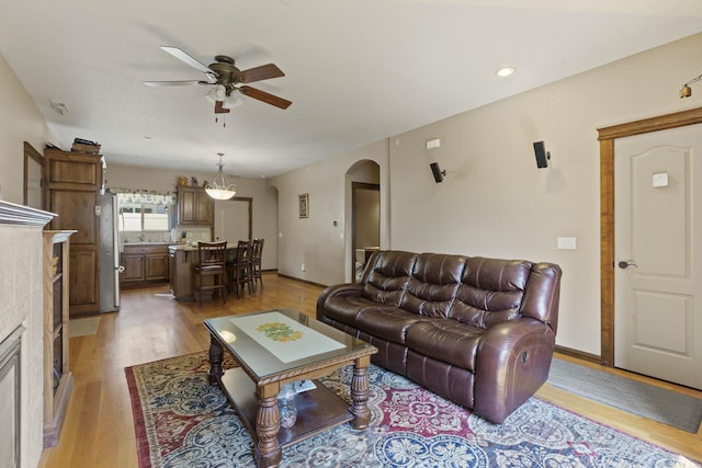 living room with ceiling fan and light hardwood / wood-style floors