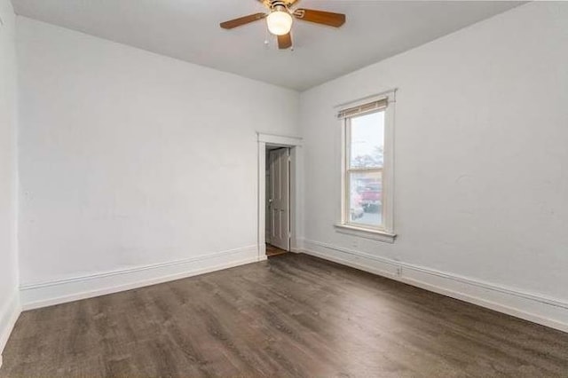 empty room with ceiling fan and dark hardwood / wood-style flooring