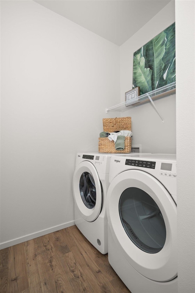 laundry area featuring washing machine and dryer and hardwood / wood-style floors