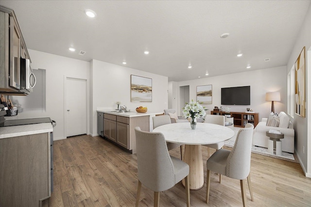 dining area featuring sink and light wood-type flooring